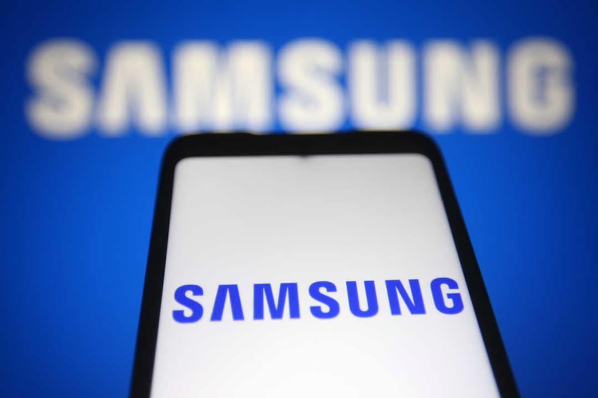 Tela de um smartphone Samsung, em frente de um fundo azul com a logo da Samsung. Samsung libera serviço GRATUITO.