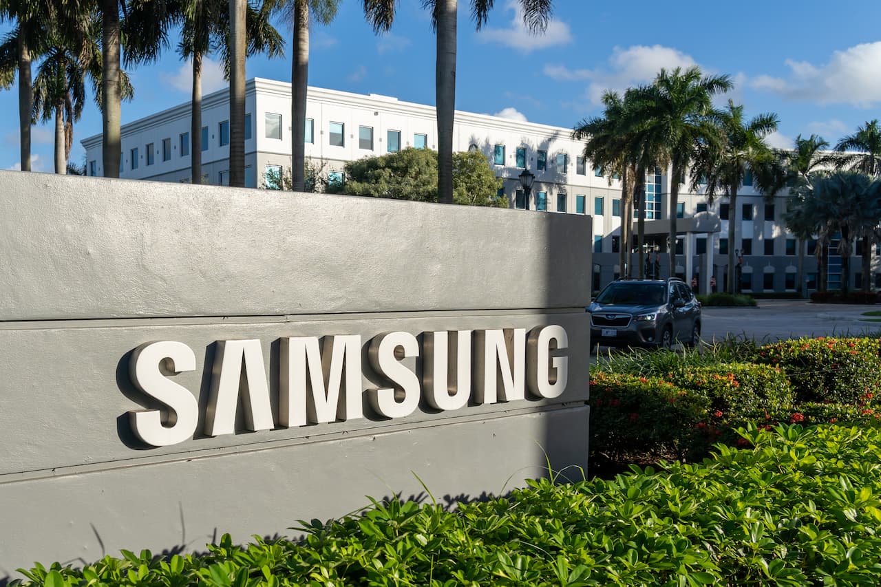 A imagem mostra uma placa com o nome "Samsung", frente da empresa.