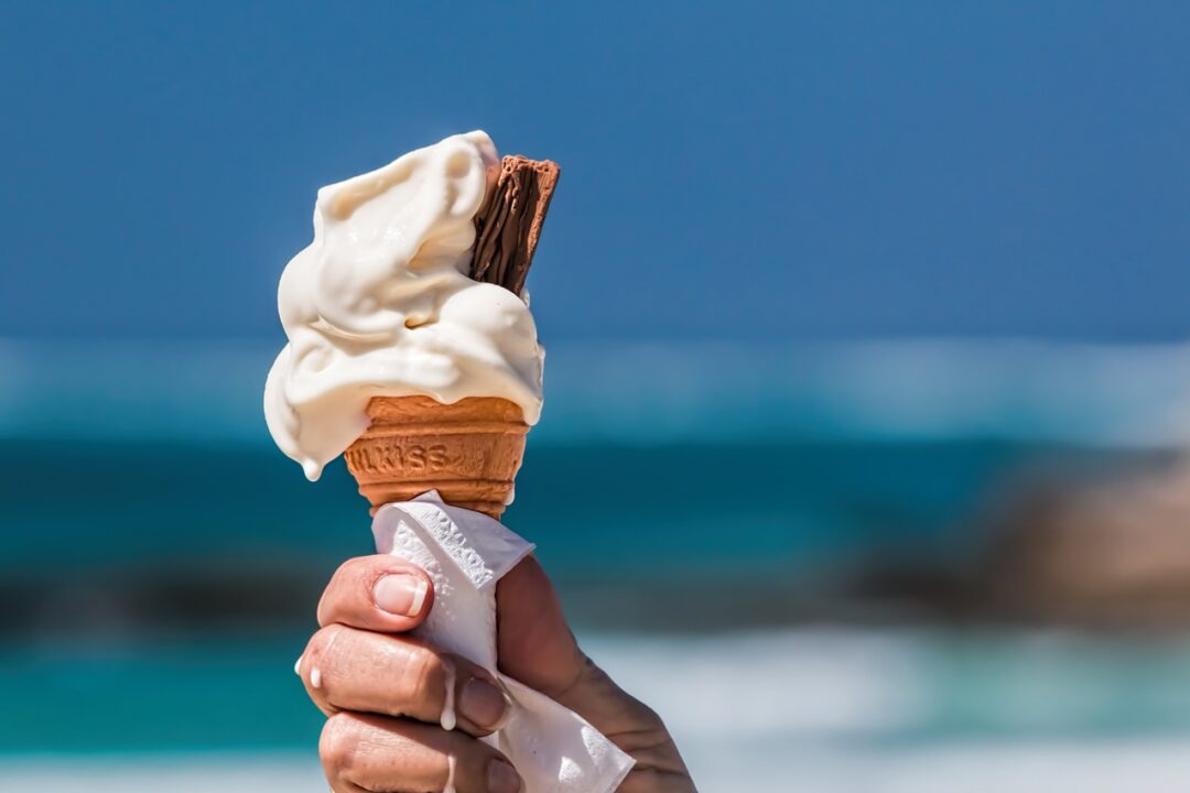 Imagem de uma mão segurando um sorvete de casca.