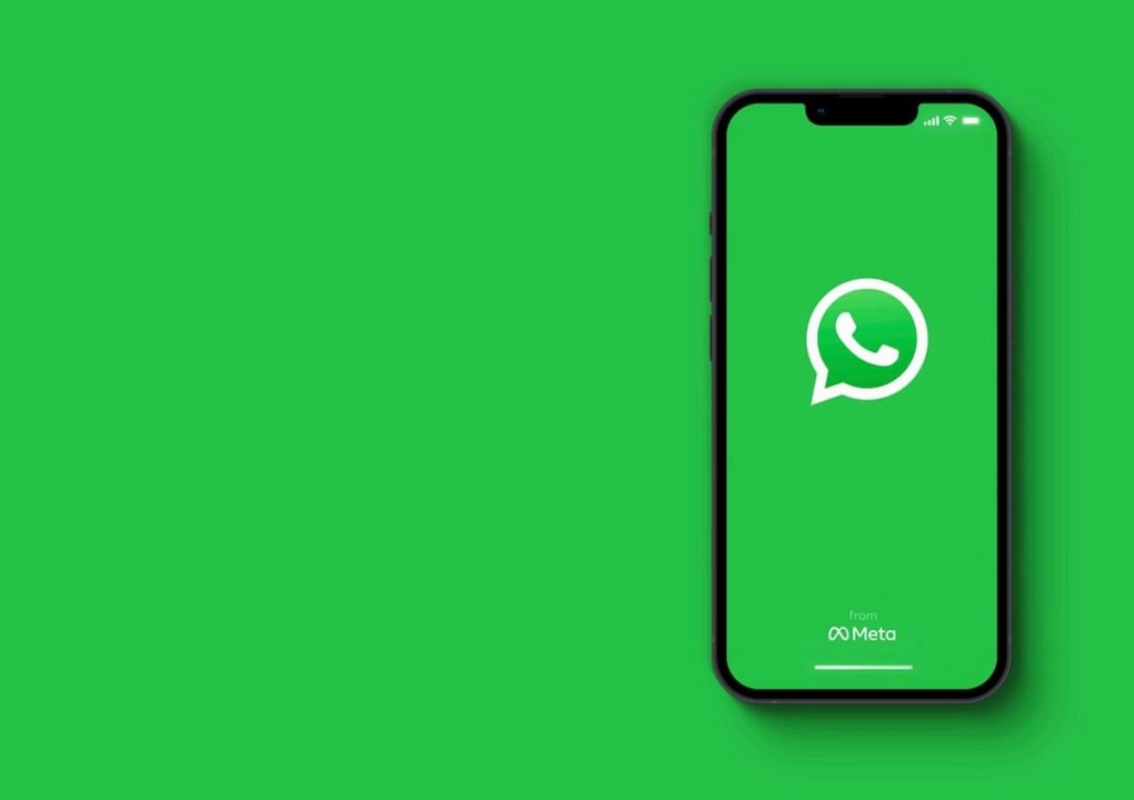 Celular com WhatsApp aberto em fundo verde