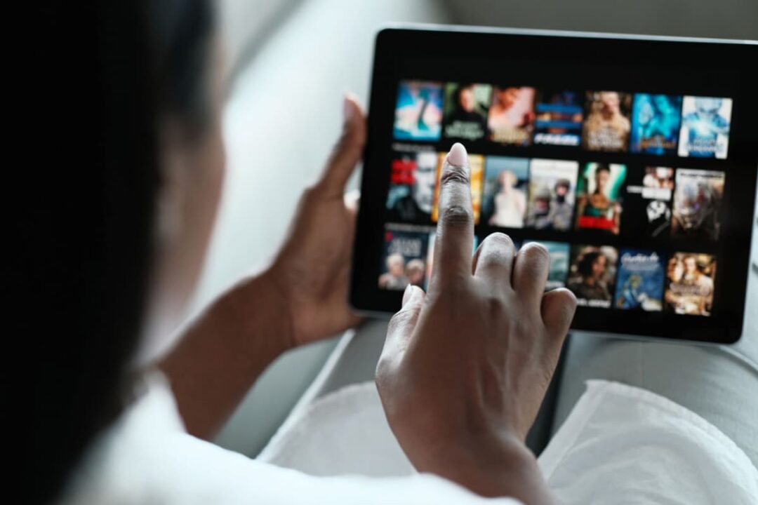 Mulher escolhendo o que assistir em streamings mais baratos que a Netflix